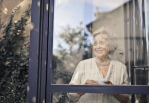 woman in white dress shirt standing in front of glass window