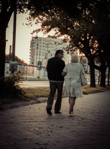 couple walking on sidewalk during daytime