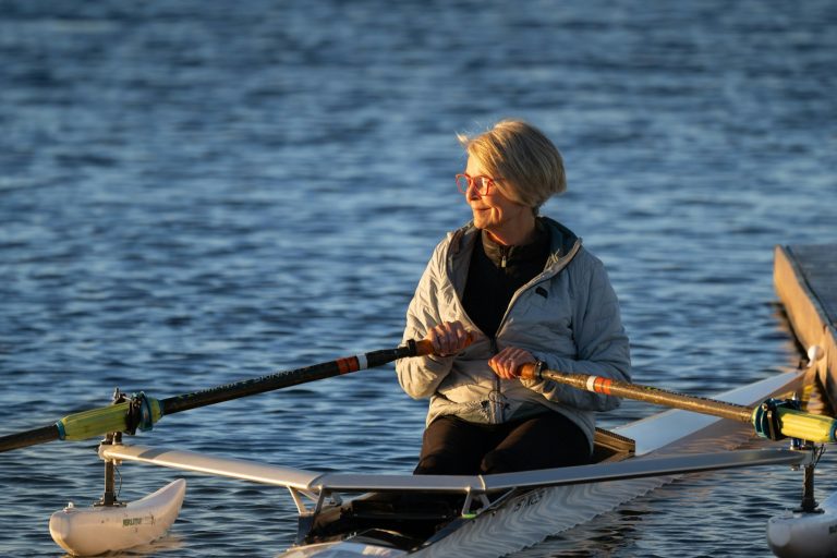 Joint Replacement Surgery A woman rows her boat on calm water.