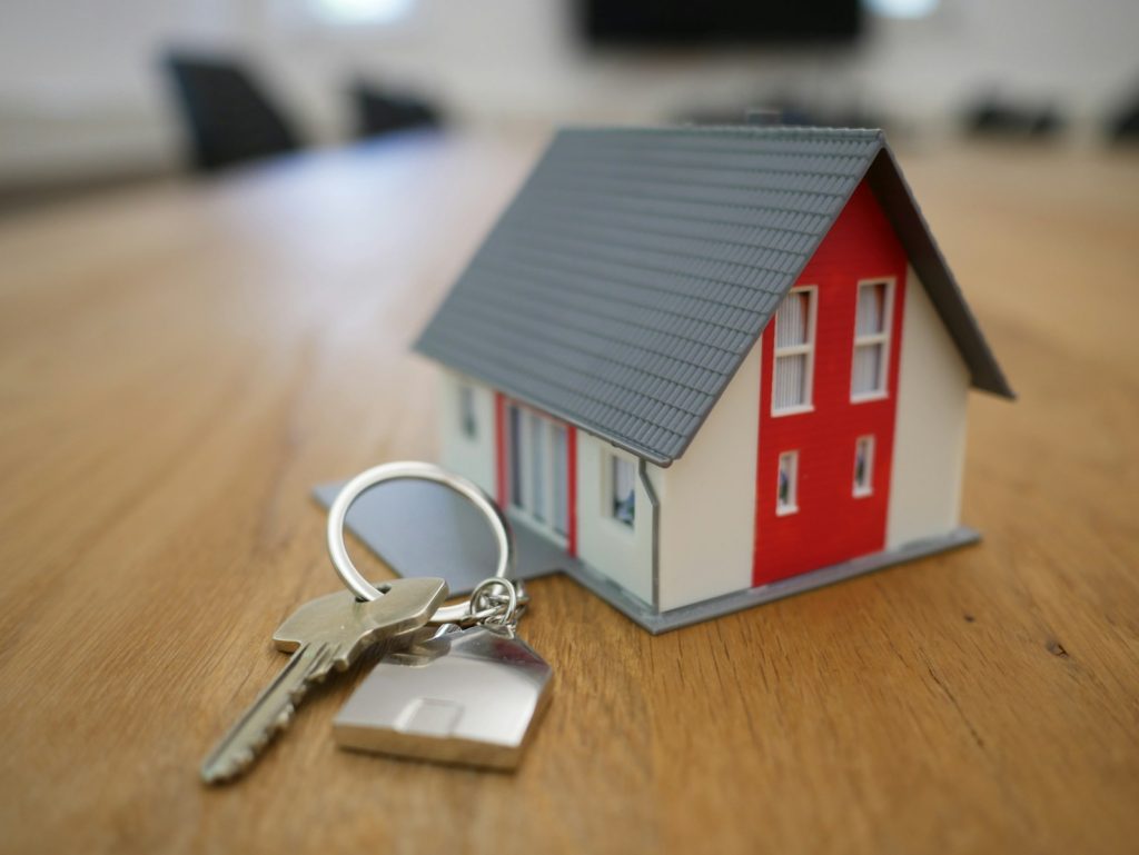 When You're Moving, aticle by Don Enos of Northwest Listings; white and red wooden house miniature on brown table